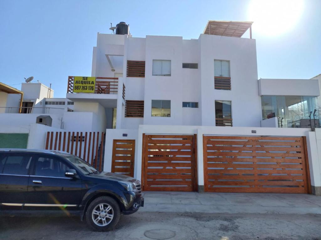 una macchina nera parcheggiata di fronte a una casa di DÚPLEX CON VISTA A TODA LA BAHÍA DE NAPLO a Pucusana