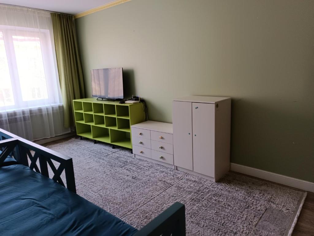 - une chambre avec un lit, une commode et une fenêtre dans l'établissement Квартира для семьи, à Almaty