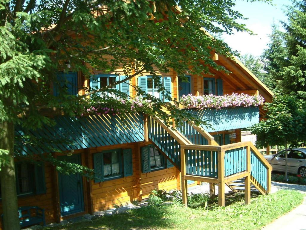 ein Holzhaus mit einer Treppe davor in der Unterkunft Ferienhaus Mitterdorf in Mitterfirmiansreut