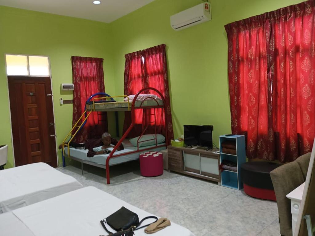 a bedroom with two bunk beds and red curtains at Airport Kota Bharu Transit Inn in Kota Bharu