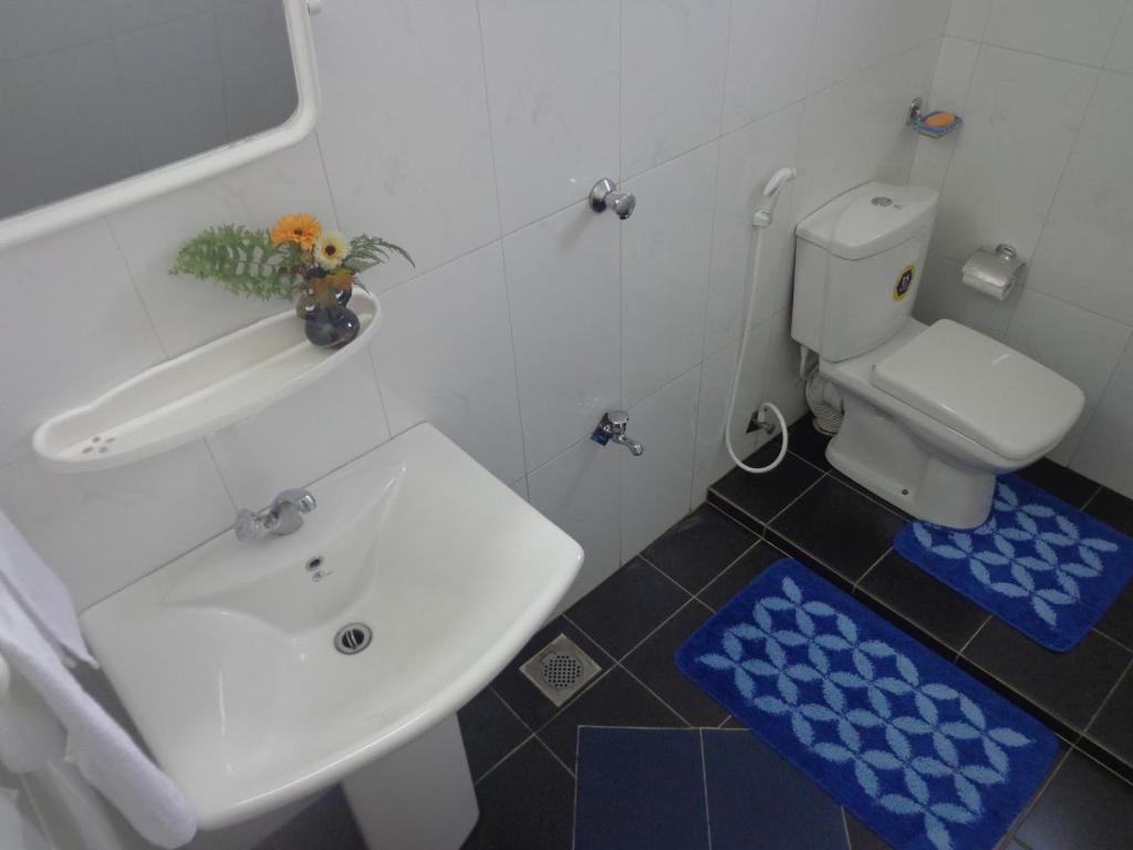 a white bathroom with a sink and a toilet at Asoka Resident Kalutara in Kalutara