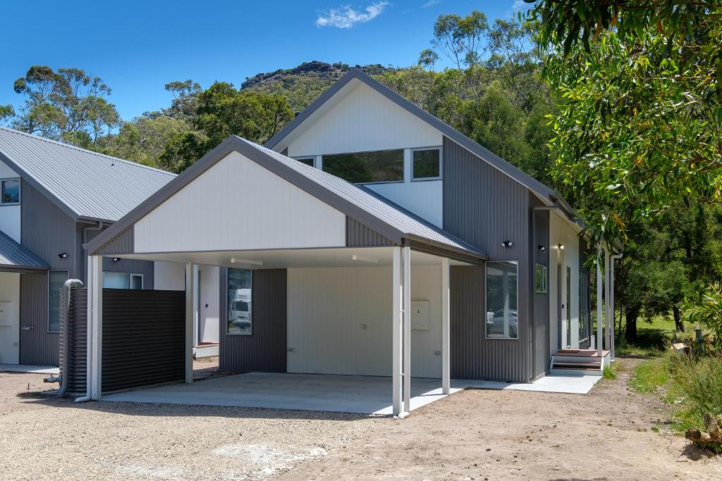 ein Haus mit Garage und Bergen im Hintergrund in der Unterkunft Serenity Halls Gap 4 Absolute NP Frontage in Halls Gap