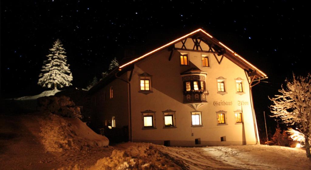 a large building with lights on in the snow at night at Apartments HAUS SCHÖN - Preise inclusive Pitztal Sommer Card in Jerzens
