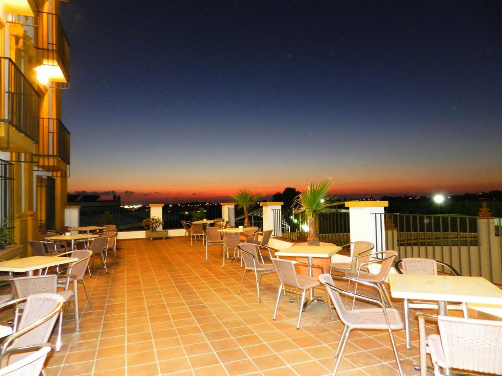 a balcony with tables and chairs on a building at Hotel Balneario de Chiclana in Chiclana de la Frontera