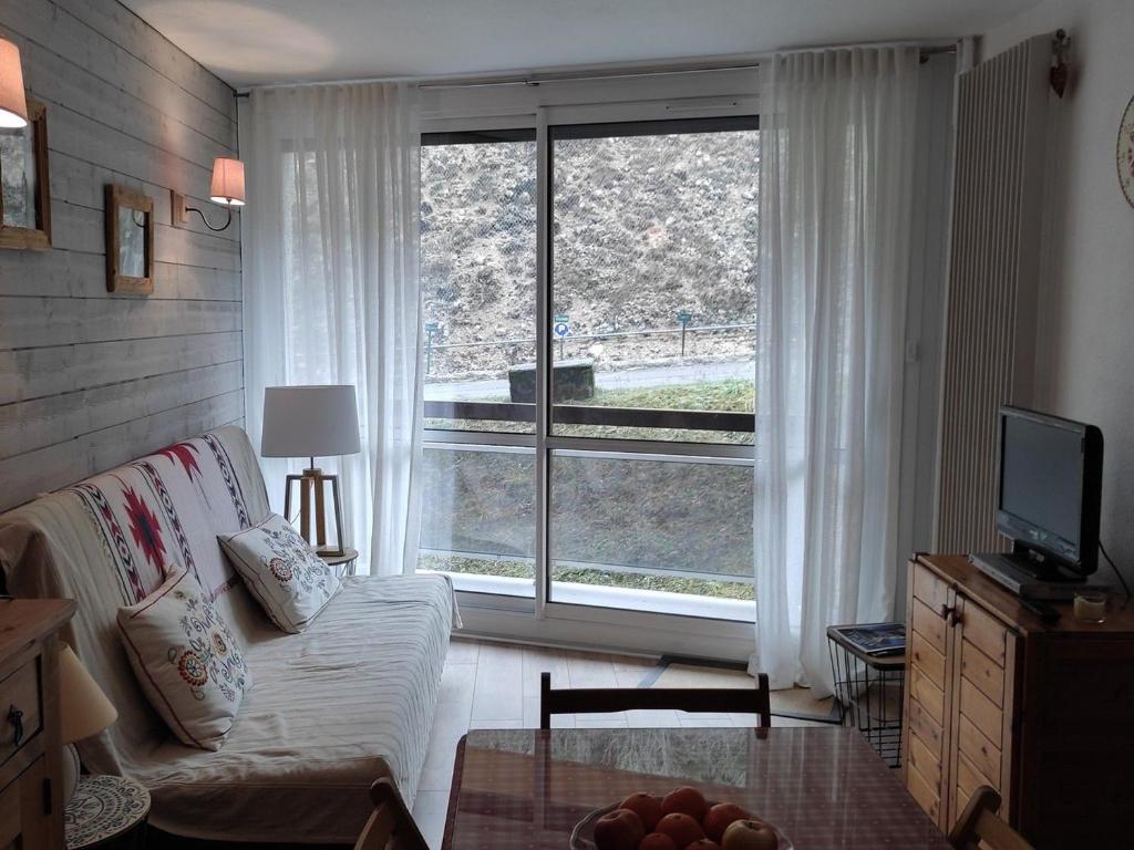 un salon avec un canapé et une grande fenêtre dans l'établissement Appartement cosy 40m², 6 couchages, pied des pistes avec balcon, à Villard-de-Lans - FR-1-689-116, à Villard-de-Lans