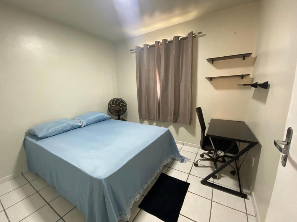a small bedroom with a bed and a desk at Apto refúgio 301 em São Luís/MA (inteiro) in São Luís