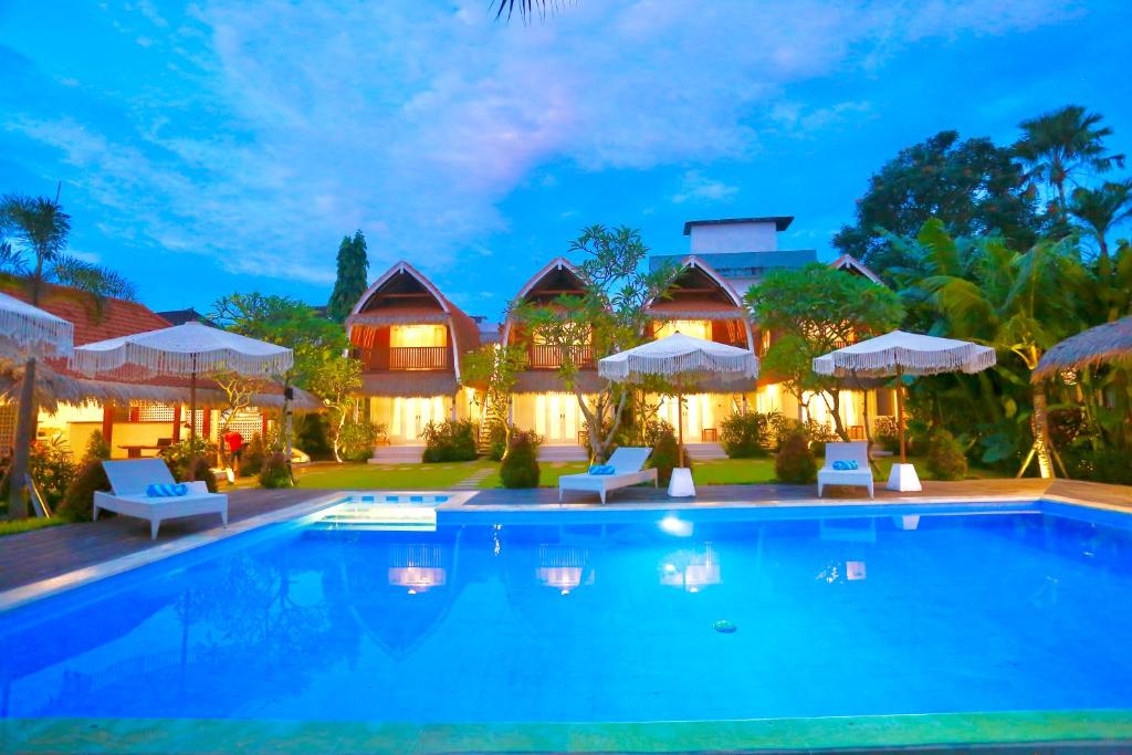 una villa con piscina por la noche en 37 Sunset Village Bali, en Canggu