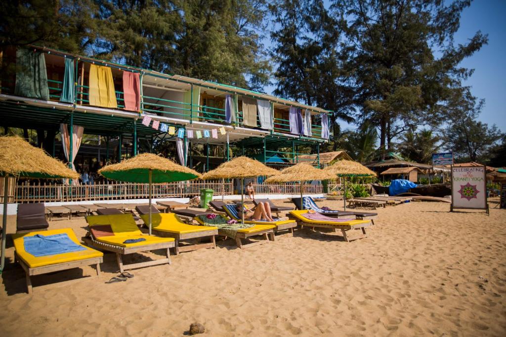 a group of chairs and umbrellas on a beach at Kranti Yoga Tradition - Beach Resort in Patnem
