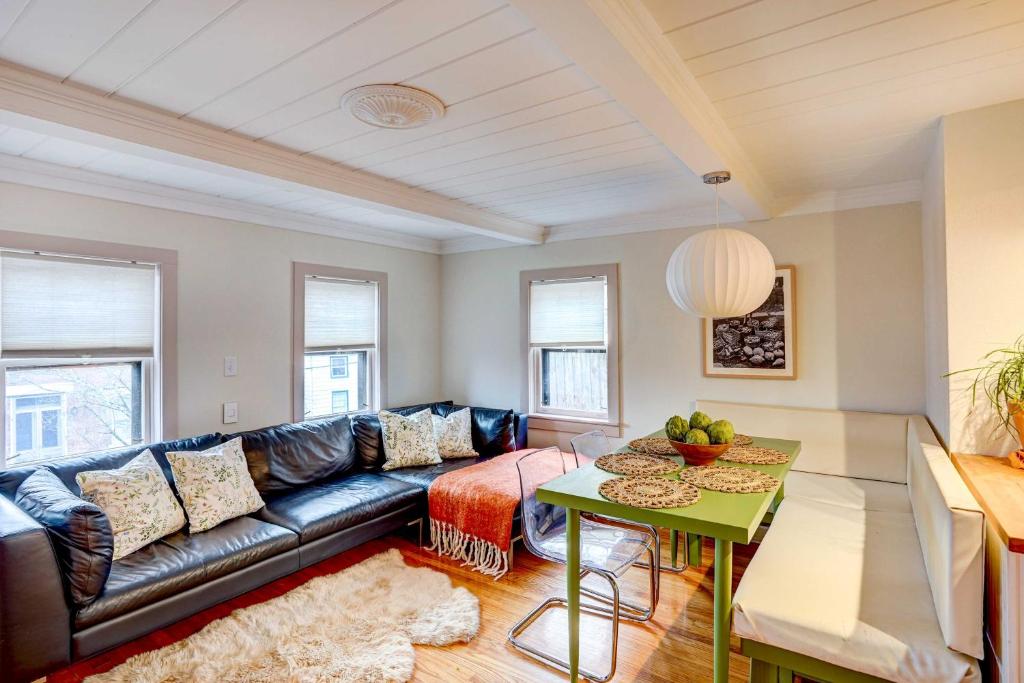 sala de estar con sofá de cuero negro y mesa en Saugerties Home 3 Decks and Hudson River View en Saugerties