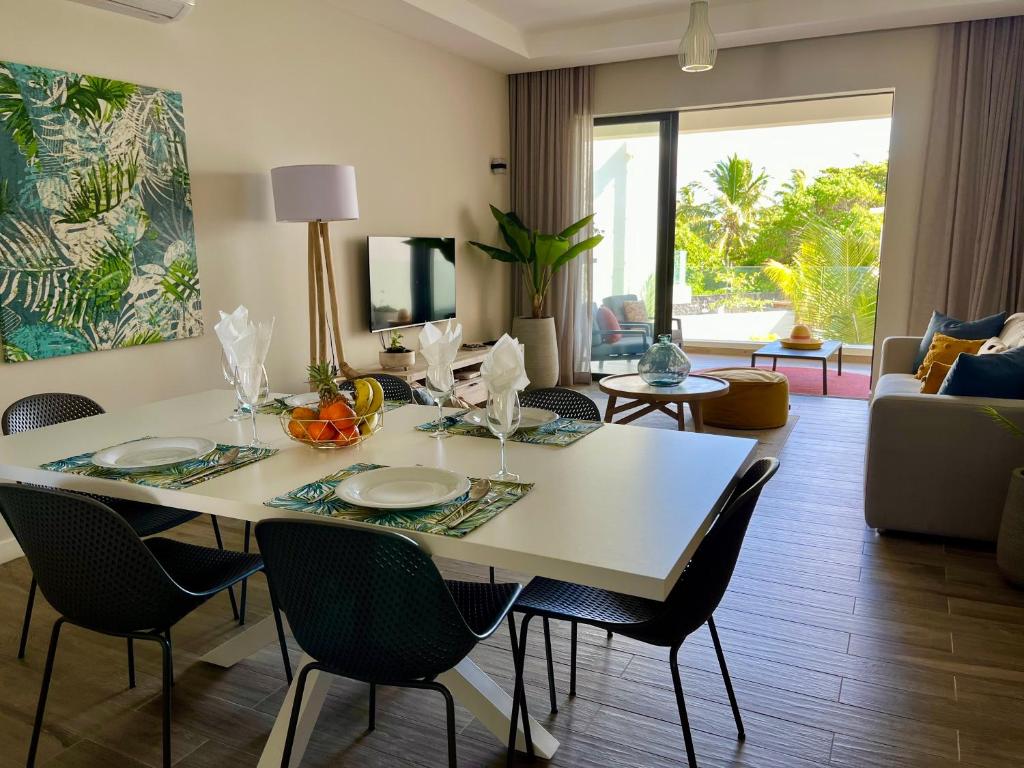 a living room with a white table and chairs at Tropical beachfront apartment in Belle Mare