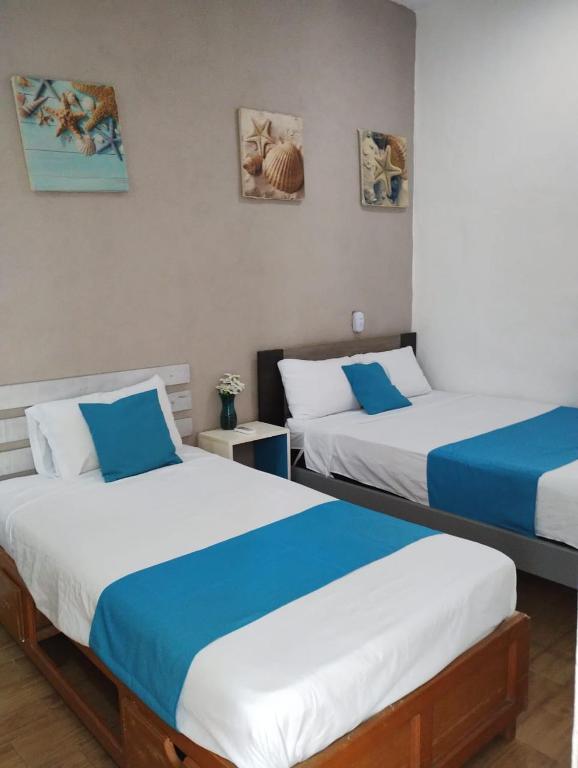 科蘇梅爾的住宿－Hermosa Casa Esencia en Cozumel，蓝色和白色的客房内的两张床