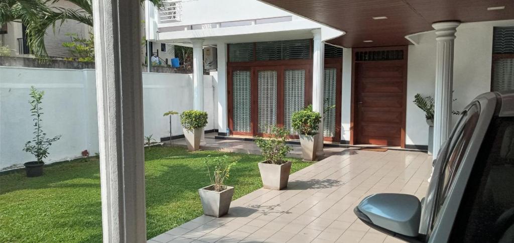 Heritage Villa colombo7 في كولومبو: منزل مع شرفة مع نباتات الفخار