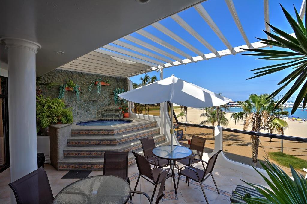 een patio met een tafel met stoelen en een parasol bij Hotel Casablanca Salinas in Salinas