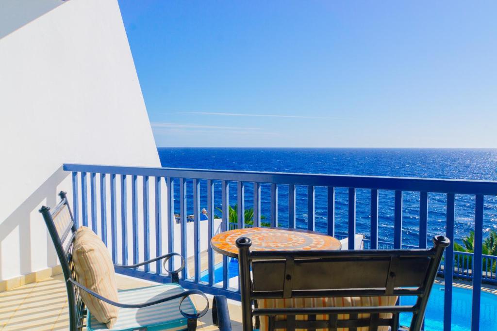 balcone con tavolo, sedie e vista sull'oceano di La Casa Azul a Puerto Calero