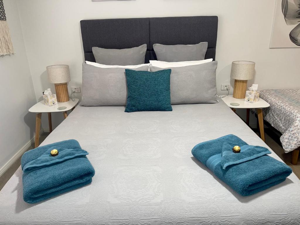 a bedroom with a bed with blue towels on it at Emu Retreat B&B in Tailem Bend