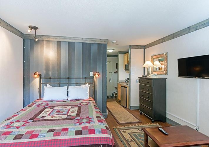 - une chambre avec un lit, un bureau et une télévision dans l'établissement Mountainside Inn 116 Hotel Room, à Telluride