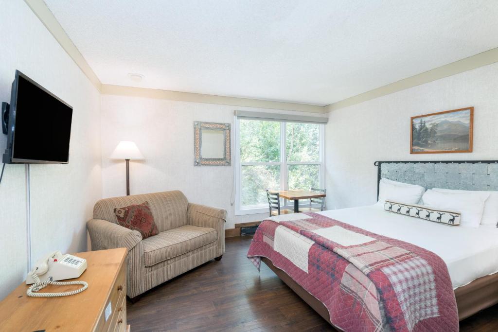 a hotel room with a bed and a couch at Mountainside Inn 411 Hotel Room in Telluride