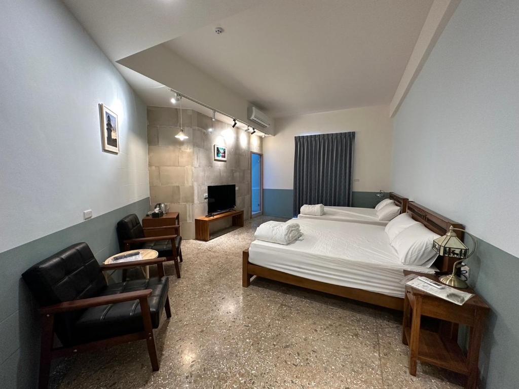 西嶼鄉的住宿－九屏文旅 JP guesthouse，一间卧室配有一张床、一张沙发和一把椅子