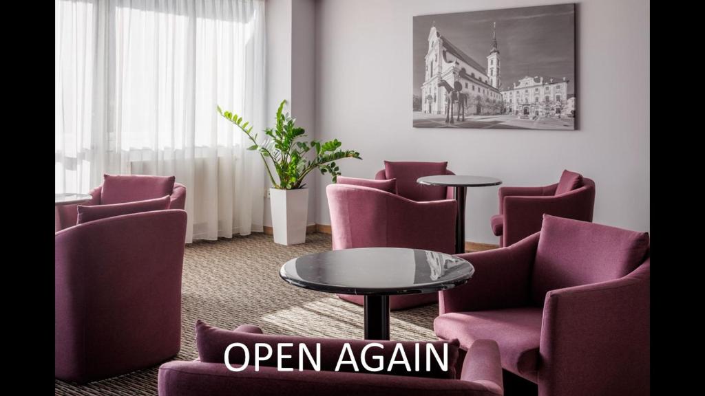 a waiting room with purple chairs and a table at OREA Hotel Voro Brno in Brno