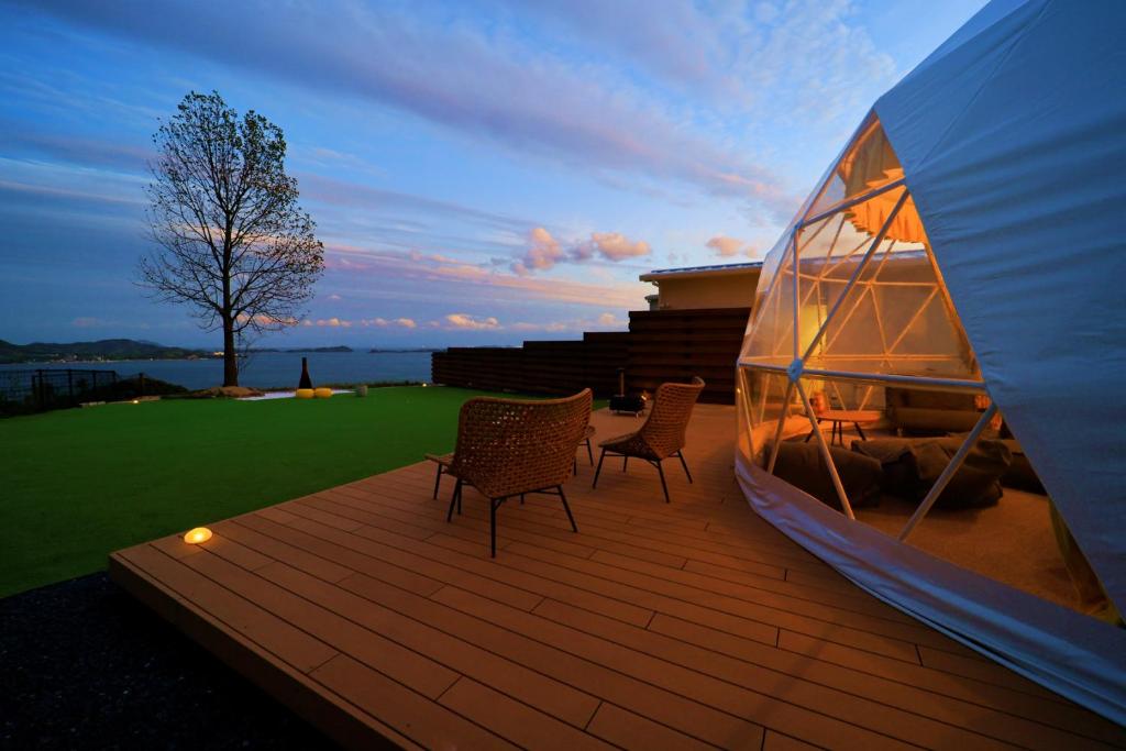 - terrazza in legno con 2 sedie e una tenda di LEMON FARM GLAMPING simanami a Onomichi