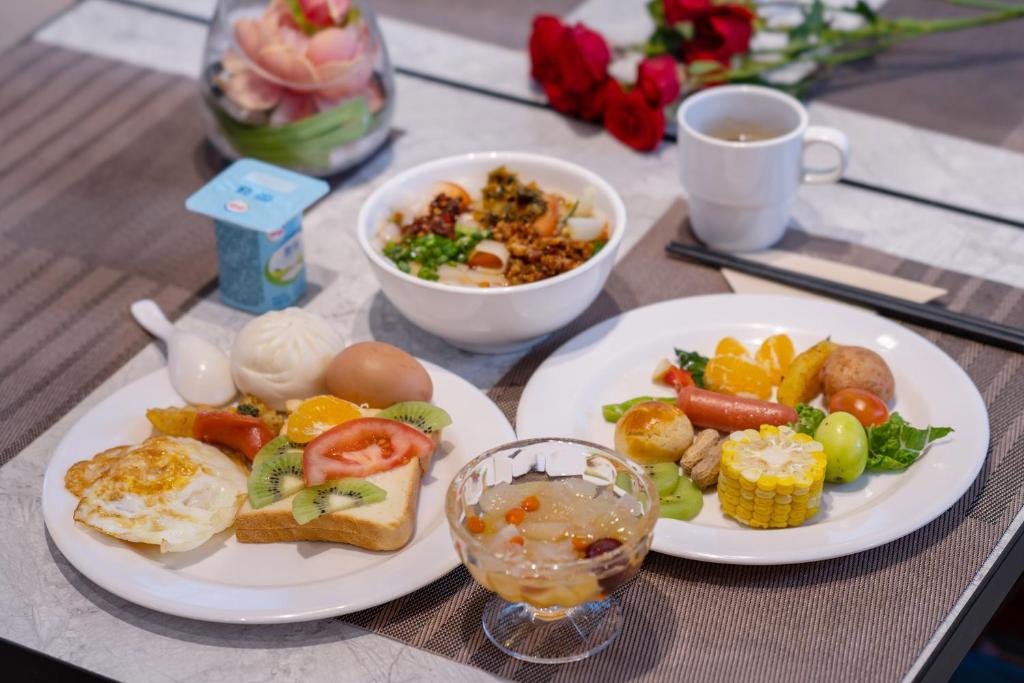 a table with two plates of food and a cup of coffee at Hanting Premium Hotel Kunming Donghua Branch in Kunming