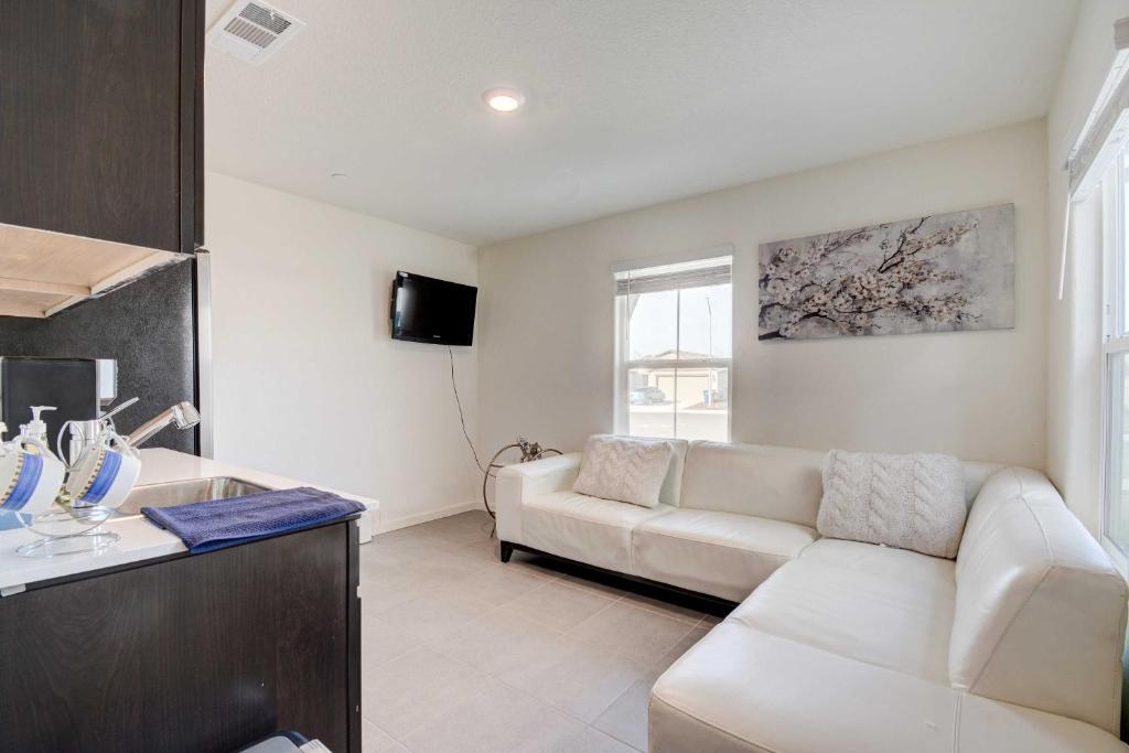 sala de estar con sofá blanco y TV en Ideally Located Merced Vacation Rental!, en Merced