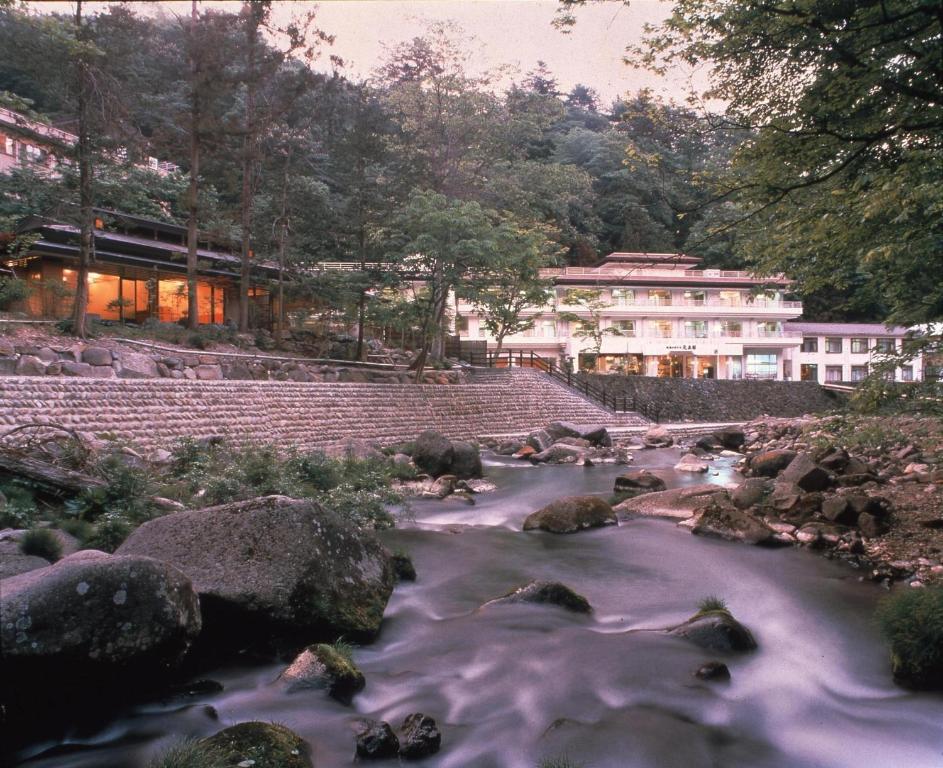 un río con rocas frente a un edificio en Gensenkan, en Nasushiobara