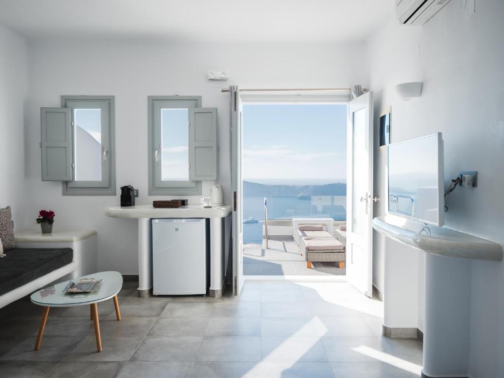a white bathroom with a view of the ocean at Vitsentzos Suites in Imerovigli