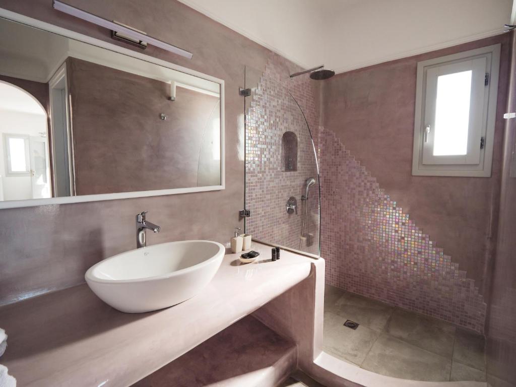 a bathroom with a white sink and a mirror at Vitsentzos Suites in Imerovigli