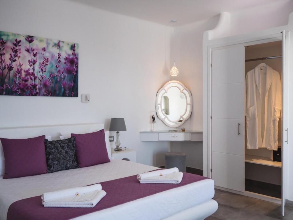 a bedroom with a bed with two towels on it at Vitsentzos Suites in Imerovigli