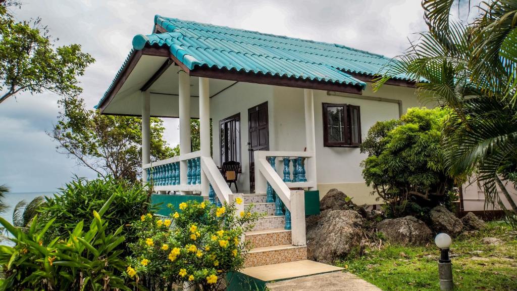 une petite maison avec un toit bleu dans l'établissement Dragon Hut Resort, à Haad Yao