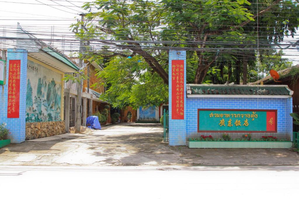 Eine Straße mit einem blauen Gebäude mit einem Schild darauf in der Unterkunft GG Sweet Home in Mae Sot