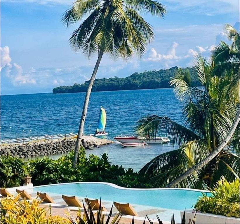 vistas a una playa con un barco en el agua en Kembali CONDO Resort with Sea View, en Davao City