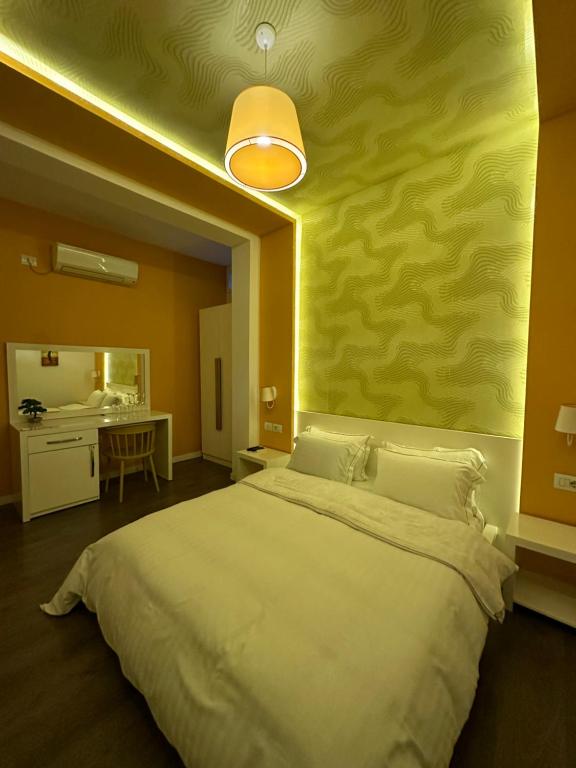 a bedroom with a large bed with a yellow wall at AL BON Park in Berat