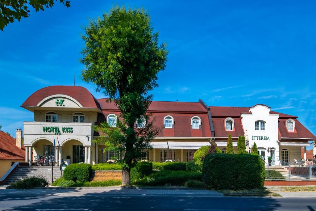 a building with a tree in front of it at Hotel Kiss in Tata