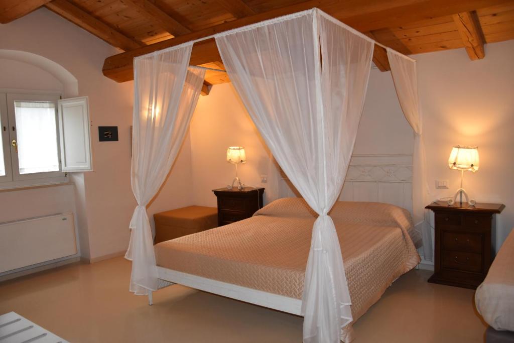 a bedroom with a canopy bed with white drapes at Il Belvedere in Matera