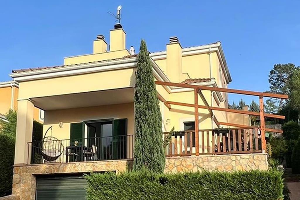 Una gran casa amarilla con balcón frente a ella en Detached house with pool nearby Girona en Sant Julià De Ramis