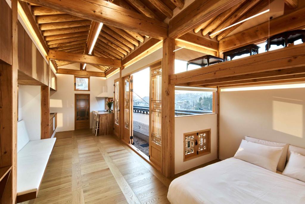 an attic bedroom with a bed and a large window at Luxury hanok with private bathtub - SN13 in Seoul