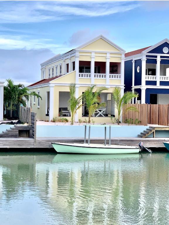 a boat is docked in front of a house at Lagoon Lounge - Waterfront villa with private pool in Kralendijk