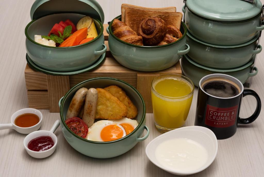A styled breakfast spread with fruit, pastries, a cooked plate, juice, coffee and yogurt.