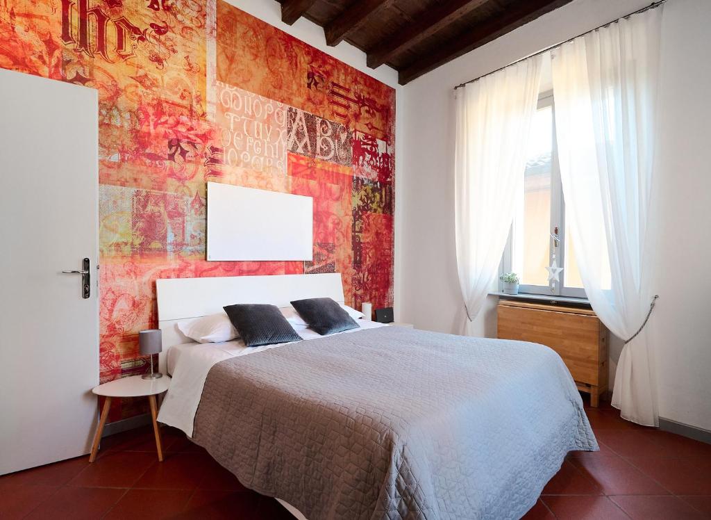 a bedroom with a bed and a red wall at Room With a View Bergamo Alta in Bergamo