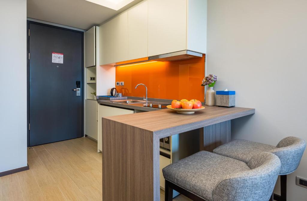A close view of the fitted kitchenette and its two upholstered counter stools.