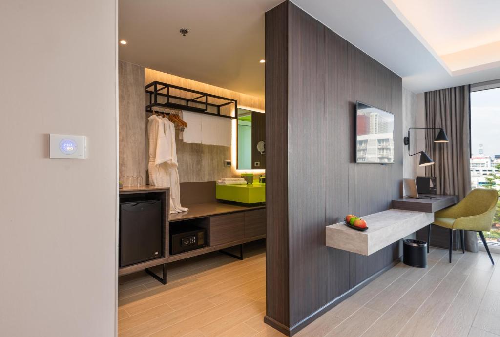A suite workspace with a narrow wall-mounted desk beside the bathroom and dressing area.