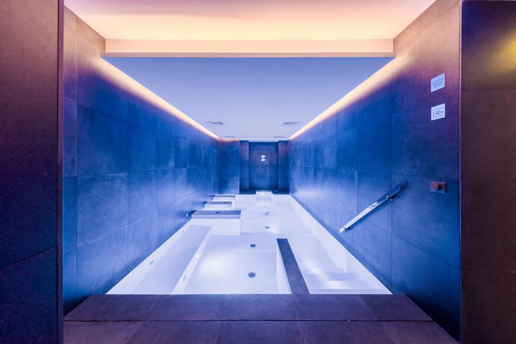 a bathroom with a bath tub with blue walls at LHP Napoli Palace & SPA in Naples