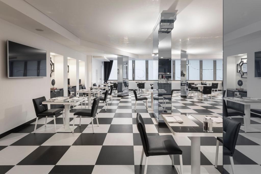 a restaurant with tables and chairs on a checkered floor at LHP Napoli Palace & SPA in Naples
