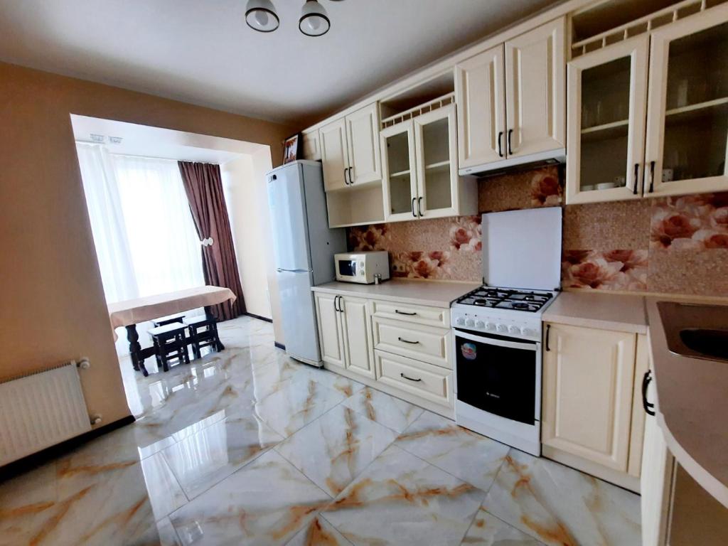 a kitchen with white cabinets and a stove top oven at Sun Hall in Lviv