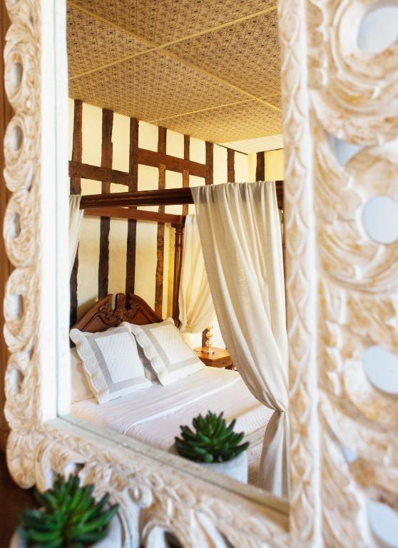 a mirror reflection of a bed in a room at Cafe de france Eauze in Eauze