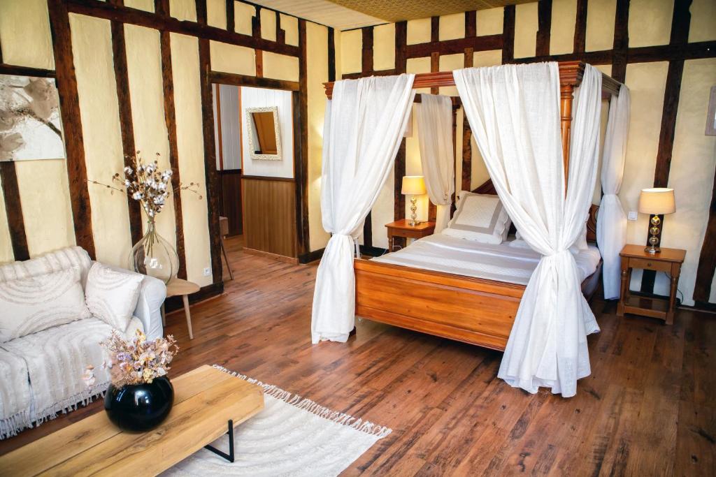 una camera da letto con letto, tende e divano di Cafe de france Eauze a Eauze