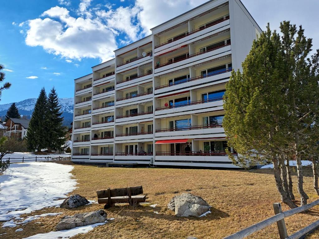 un edificio con un banco delante de él en Allod (166 Da) Whg. Nr. 103, en Lenzerheide