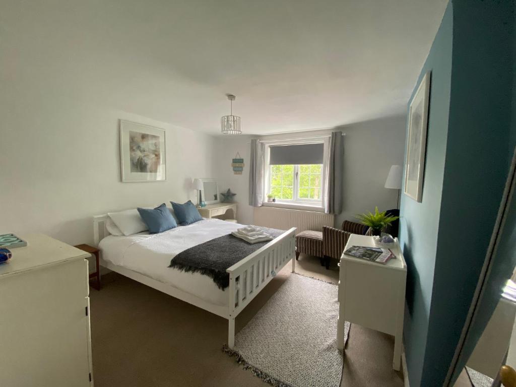 a bedroom with a bed and a window at Fern Cottage Iden, Rye in Iden